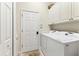 Convenient laundry room equipped with washer, dryer, and ample cabinet space for storage at 1806 85Th Nw Ct, Bradenton, FL 34209