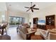 Bright living room featuring neutral furniture, tile flooring, ceiling fan, and access to the outdoor patio at 1806 85Th Nw Ct, Bradenton, FL 34209