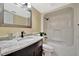Bathroom features a marble countertop, dark wood cabinets, and a shower-tub combo with white tile surround at 2311 14Th W Ave # 208, Palmetto, FL 34221