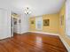 Sunny bedroom with classic wood floors, yellow walls, closet, and vintage chandelier at 2315 Mcclellan Pkwy, Sarasota, FL 34239