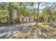 Charming home with distinctive turquoise door, white columns, and a small balcony surrounded by lush trees at 2315 Mcclellan Pkwy, Sarasota, FL 34239