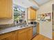 Well-lit kitchen with granite countertops, stainless steel appliances and wood cabinets at 2315 Mcclellan Pkwy, Sarasota, FL 34239