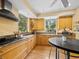 Functional kitchen featuring warm wood cabinets, granite counters and a gas range at 2315 Mcclellan Pkwy, Sarasota, FL 34239