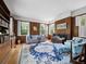 Cozy living room with wood paneled walls, large rug, and shuttered windows at 2315 Mcclellan Pkwy, Sarasota, FL 34239