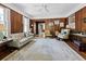 Living room featuring wood paneling, light rug and view into the sunroom at 2315 Mcclellan Pkwy, Sarasota, FL 34239