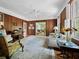 Bright living room with wood paneling, light rug, and views into the sunroom at 2315 Mcclellan Pkwy, Sarasota, FL 34239