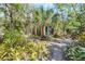 Beautifully landscaped yard with lush greenery and a charming walkway at 2315 Mcclellan Pkwy, Sarasota, FL 34239