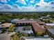 Wide aerial view with parking lot and red tile roof with open sky and palms on a clear sunny day showing community features at 236 Harbor S Dr # 205, Venice, FL 34285