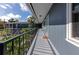 Exterior corridor with blue siding, black railings and steps to a second floor. Palm trees visible from the walkway at 236 Harbor S Dr # 205, Venice, FL 34285