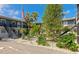 Two-story condo with a landscaped courtyard, featuring vibrant green trees and a relaxing outdoor seating area at 236 Harbor S Dr # 205, Venice, FL 34285