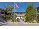 Inviting two-story condo with a landscaped courtyard, stairs to the left, and an American flag in the center at 236 Harbor S Dr # 205, Venice, FL 34285