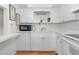 Bright kitchen features white cabinetry, appliances, and a minimalist design at 236 Harbor S Dr # 205, Venice, FL 34285