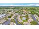 Wide aerial shot showing the layout of this villa community and its pool, surrounded by lush greenery and mature trees at 2802 Swifton Dr # V102, Sarasota, FL 34231
