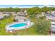 Aerial view highlighting the community pool, deck, and lush landscaping surrounding the villa, complete with an American flag at 2802 Swifton Dr # V102, Sarasota, FL 34231