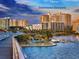 Scenic view of Downtown Sarasota skyline, featuring modern buildings, lush palm trees, and sparkling waterfront under a dramatic sunset sky at 2802 Swifton Dr # V102, Sarasota, FL 34231