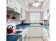 Bright kitchen with white cabinets, blue countertops, and a window offering views at 2802 Swifton Dr # V102, Sarasota, FL 34231