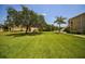 Beautiful backyard featuring a lush lawn, mature trees, and well-maintained landscaping around the property at 3015 Chianti Ct # 104, Sarasota, FL 34237
