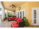 Inviting outdoor lounge area with red cushioned seating, ceiling fans, and access to the building's interior at 3015 Chianti Ct # 104, Sarasota, FL 34237