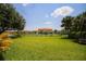 Scenic view of a tennis court surrounded by lush greenery, palm trees and meticulously kept landscaping at 3015 Chianti Ct # 104, Sarasota, FL 34237