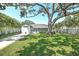 Expansive backyard featuring a mature shade tree, privacy fence, and a screened in porch at 322 35Th Ne Ave, St Petersburg, FL 33704