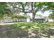 Expansive backyard featuring a mature shade tree, privacy fence, and a screened in porch at 322 35Th Ne Ave, St Petersburg, FL 33704