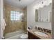 Bathroom with marble tiling around tub and shower with updated vanity and lighting at 322 35Th Ne Ave, St Petersburg, FL 33704