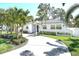 Charming single-story home with a circular driveway, lush landscaping and mature palm trees at 322 35Th Ne Ave, St Petersburg, FL 33704