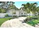 Charming single-story home with a circular driveway, lush landscaping and mature palm trees at 322 35Th Ne Ave, St Petersburg, FL 33704