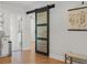 View of a modern black sliding barn door leading into another room of the house at 322 35Th Ne Ave, St Petersburg, FL 33704