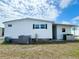 The home's exterior showing well-maintained white siding, and a side yard with green bins at 3221 Sweet Bay Ter, Sarasota, FL 34237