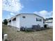 Exterior side view of the home featuring white siding, and green waste bins at 3221 Sweet Bay Ter, Sarasota, FL 34237