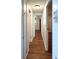 Hallway with wood floors and white walls leads to the bedrooms at 3221 Sweet Bay Ter, Sarasota, FL 34237