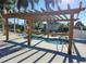Relaxing hot tub with clear water and a wooden pergola, surrounded by lush greenery and lounge seating at 3221 Sweet Bay Ter, Sarasota, FL 34237