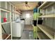 A functional laundry area featuring a washer, dryer, shelving, and ample storage space at 3221 Sweet Bay Ter, Sarasota, FL 34237