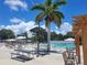 An outdoor pool area with clear blue water, seating, and a beach mural under sunny skies at 3221 Sweet Bay Ter, Sarasota, FL 34237
