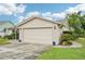 Side view of a two-car garage with an adjacent garden bed adding to the property's curb appeal at 338 Indian Key Way # 111, Englewood, FL 34223