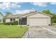 Charming single-story home featuring a two-car garage and a well-maintained front yard with lush landscaping at 338 Indian Key Way # 111, Englewood, FL 34223