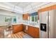 Spacious kitchen featuring stainless steel appliances and wood cabinets with a view of the dining area at 338 Indian Key Way # 111, Englewood, FL 34223
