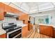 Well-lit kitchen with warm wood cabinets and stainless steel appliances opens to a dining area at 338 Indian Key Way # 111, Englewood, FL 34223