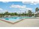 Sparkling community pool with clear blue water, surrounded by ample lounge seating and lush palm trees at 338 Indian Key Way # 111, Englewood, FL 34223