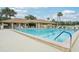 Large swimming pool with blue water, lounge chairs, and a nearby clubhouse for leisure and recreation at 338 Indian Key Way # 111, Englewood, FL 34223