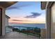 Balcony featuring glass railing and stunning view of the clear blue waters at sunset at 340 Gulf Of Mexico Dr # 124, Longboat Key, FL 34228