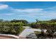 Scenic view of a paved path leading to the water, bordered by lush greenery and blue skies at 340 Gulf Of Mexico Dr # 124, Longboat Key, FL 34228