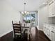 Bright dining room featuring hardwood floors, a modern chandelier, and sliding glass doors with gorgeous water views at 340 Gulf Of Mexico Dr # 124, Longboat Key, FL 34228