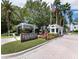 Welcoming entrance to Tangerine Bay Club with guard house, American flag, and lush landscaping at 340 Gulf Of Mexico Dr # 124, Longboat Key, FL 34228