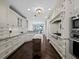 Gourmet kitchen with custom white cabinetry, granite countertops, and hardwood floors at 340 Gulf Of Mexico Dr # 124, Longboat Key, FL 34228