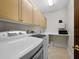 Well-organized laundry room with built-in cabinets, modern washer/dryer, and counter space at 340 Gulf Of Mexico Dr # 124, Longboat Key, FL 34228