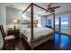 Luxurious main bedroom with a canopy bed, hardwood floors, and access to a private balcony at 340 Gulf Of Mexico Dr # 124, Longboat Key, FL 34228