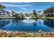 Scenic pond view with fountain, surrounded by lush tropical landscaping and residential buildings at 340 Gulf Of Mexico Dr # 124, Longboat Key, FL 34228