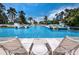 Spacious community pool with lounge chairs for relaxation in a beautiful tropical setting at 340 Gulf Of Mexico Dr # 124, Longboat Key, FL 34228